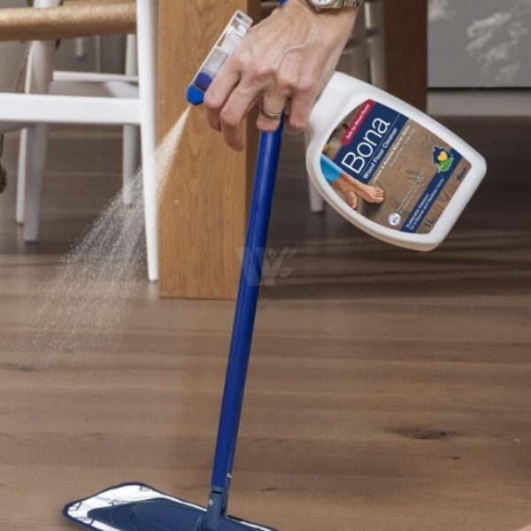 Person spraying Bona Wood Floor Cleaner onto a timber floor for easy, streak-free cleaning in New Zealand