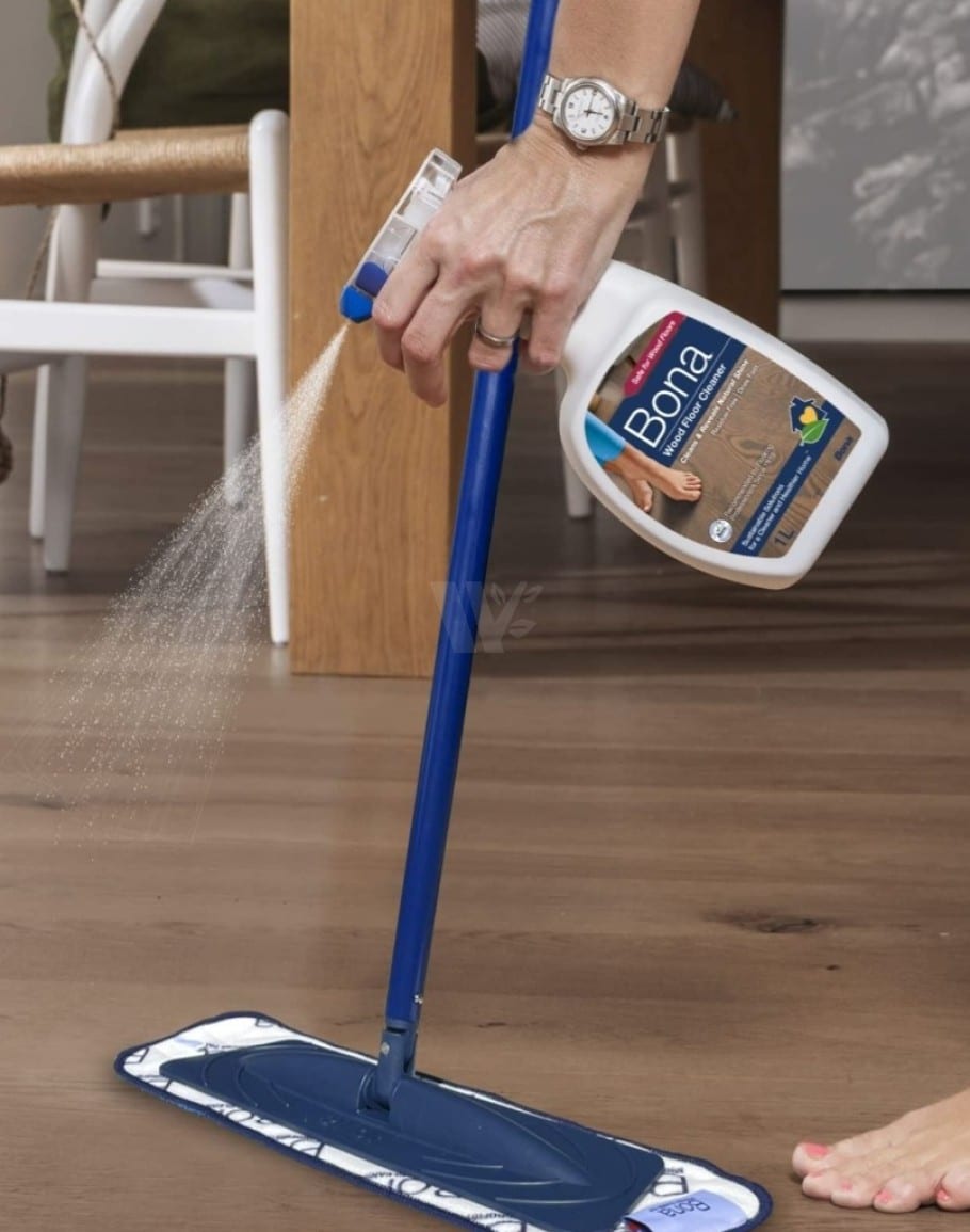 Person spraying Bona Wood Floor Cleaner onto a timber floor for easy, streak-free cleaning in New Zealand