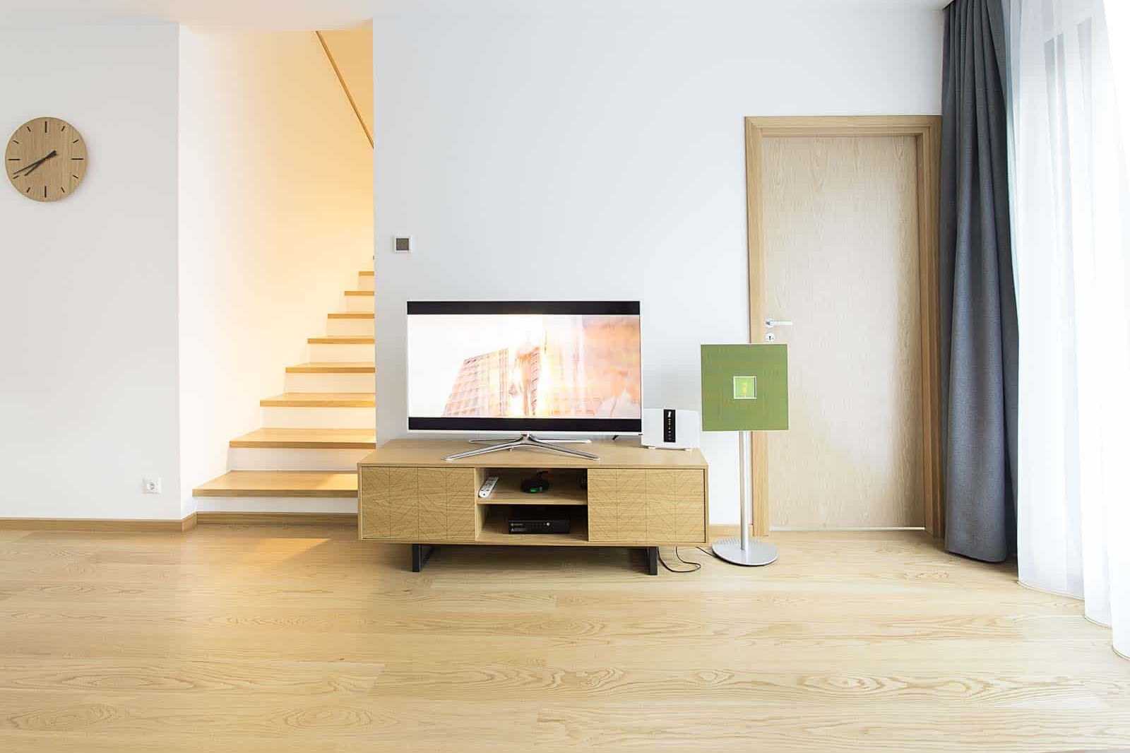 A lacquered oak timber floor in a light living room, the sealed surface catching a soft sheen.
